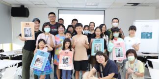 《與動物相愛的練習︱狗狗的家人時光遊戲課》學員與待認養狗狗溫馨合影，手舉認養犬隻的介紹牌。