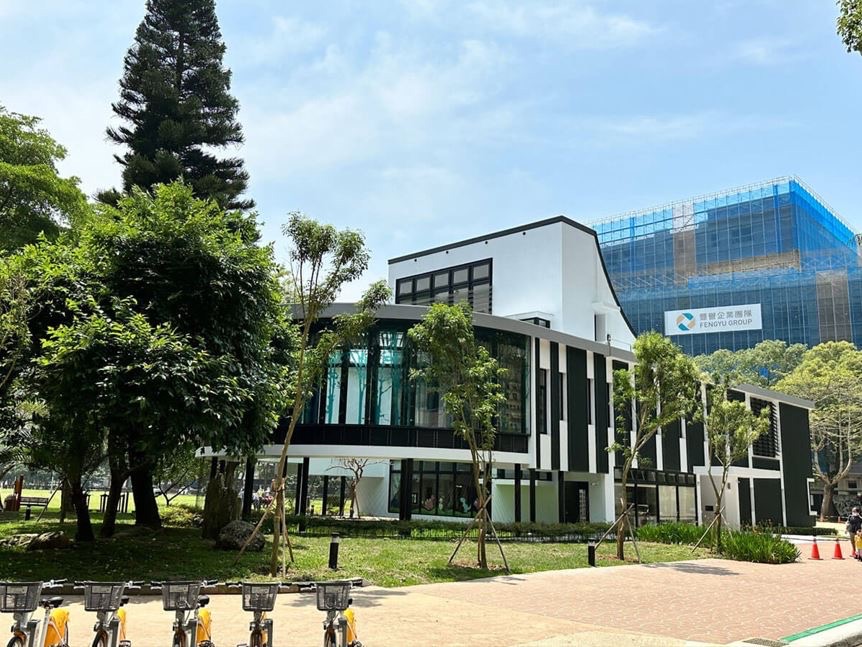 林口區李科永紀念圖書館外觀為沈穩的黑色線條及半圓形玻璃走廊佇立於綠意盎然的公園環境(圖片來源:新北市政府動物保護防疫處)